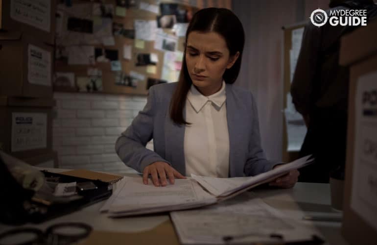 female detective working on documents for a case