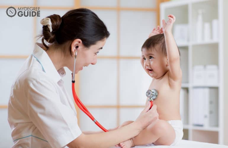 pediatric nurse checking an infant
