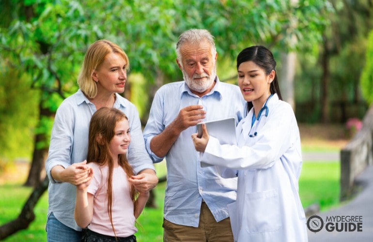health educator talking to a family in a park