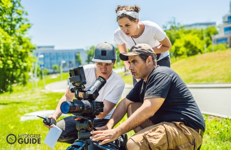 diretor de cinema dando instruções para a equipe de câmera durante as filmagens