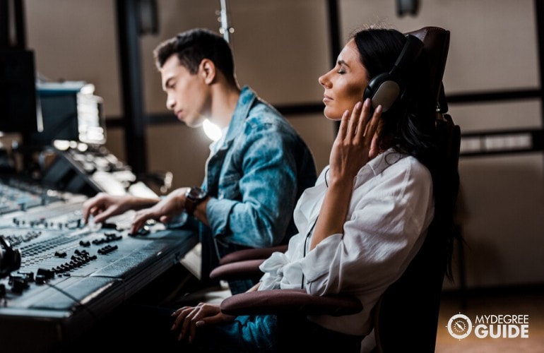 music producer listening to their music in a recording studio
