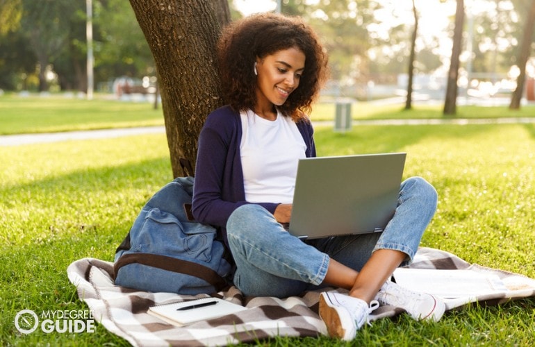 Early Childhood Education Degree student studying on her laptop in a park