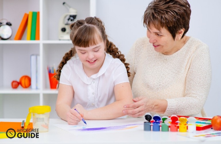 Special Education teacher teaching a child with down syndrome 