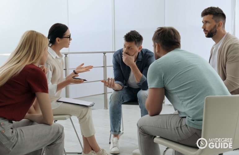 Social Psychologist discussing to a group of adults