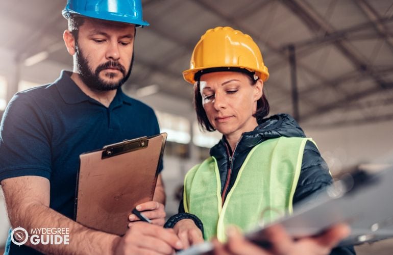 Construction Manager and Cost Estimator sign a form