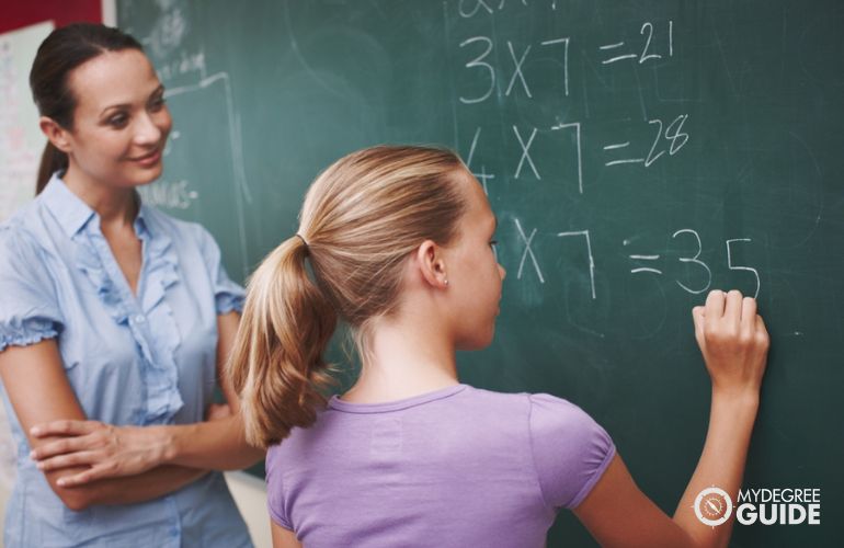Math teacher guiding a student solve a problem