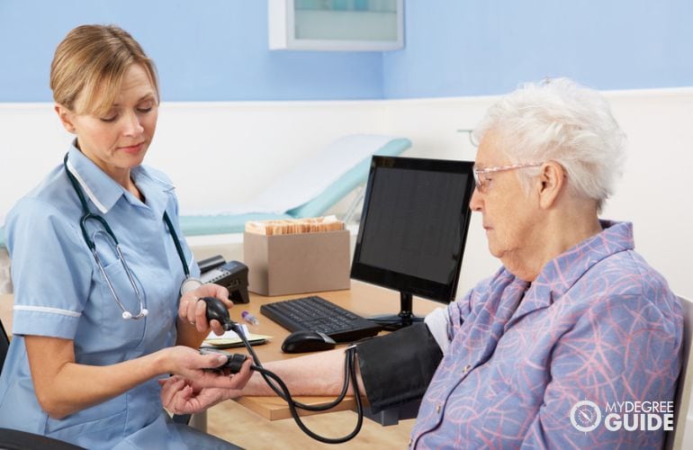 Licensed practical nurse taking patient's blood pressure