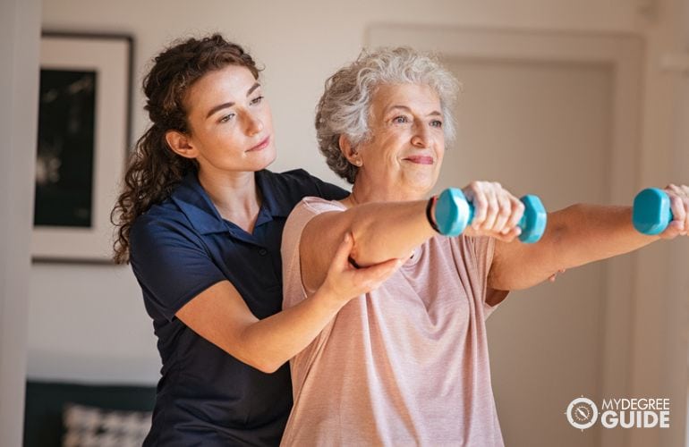 Physical therapy assistant guiding a patient with exercises