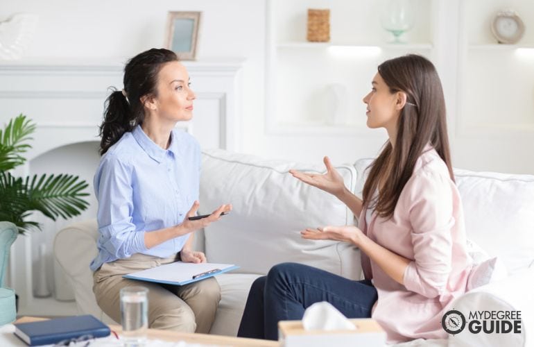 female counselor listening to a teenage girl during counseling session