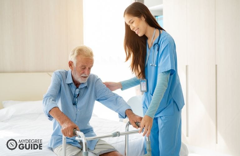 Adult Gerontology Nurse Practitioner assiting a patient to stand